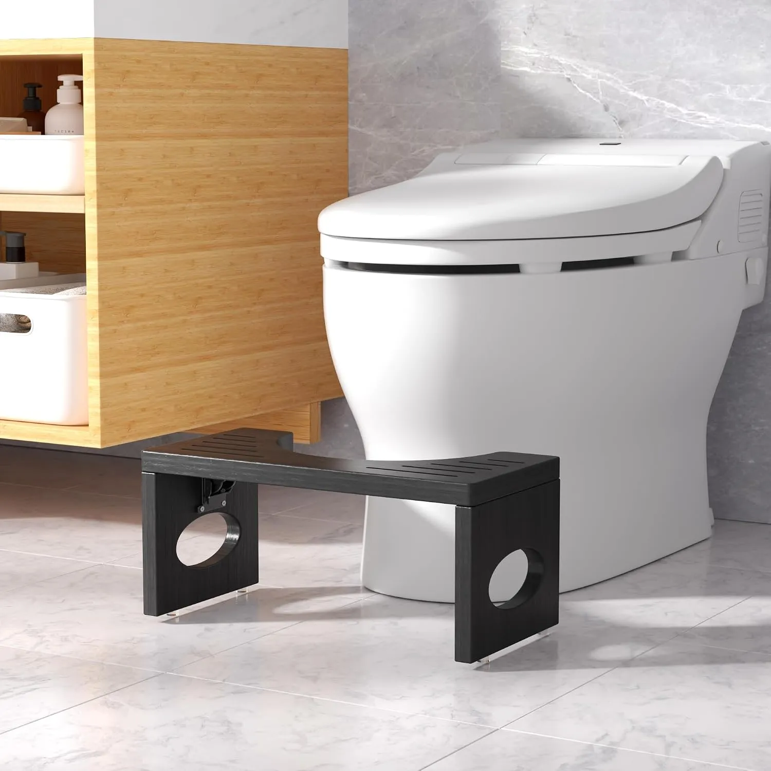 Black stool on a bathroom floor in front of a toilet