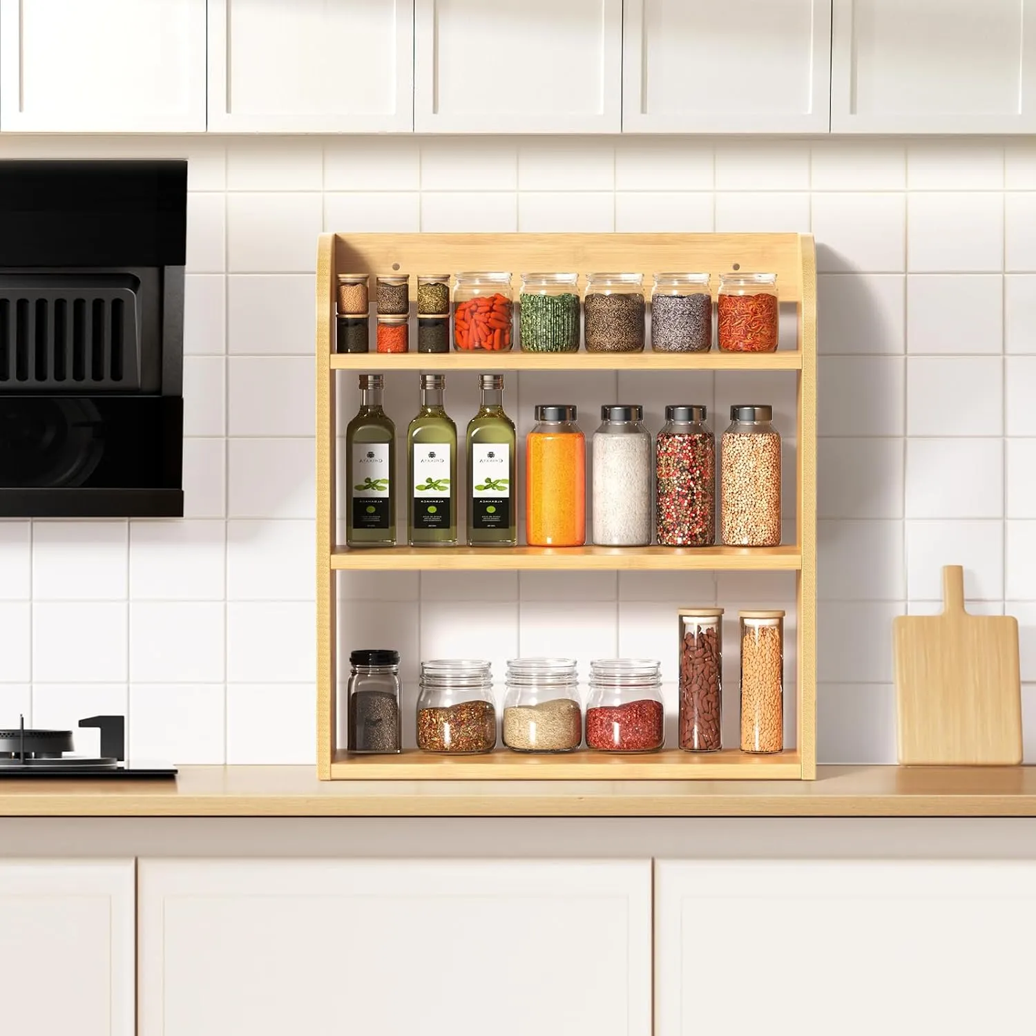 Natural 3 tier spice rack on a kitchen counter holding jars and bottles