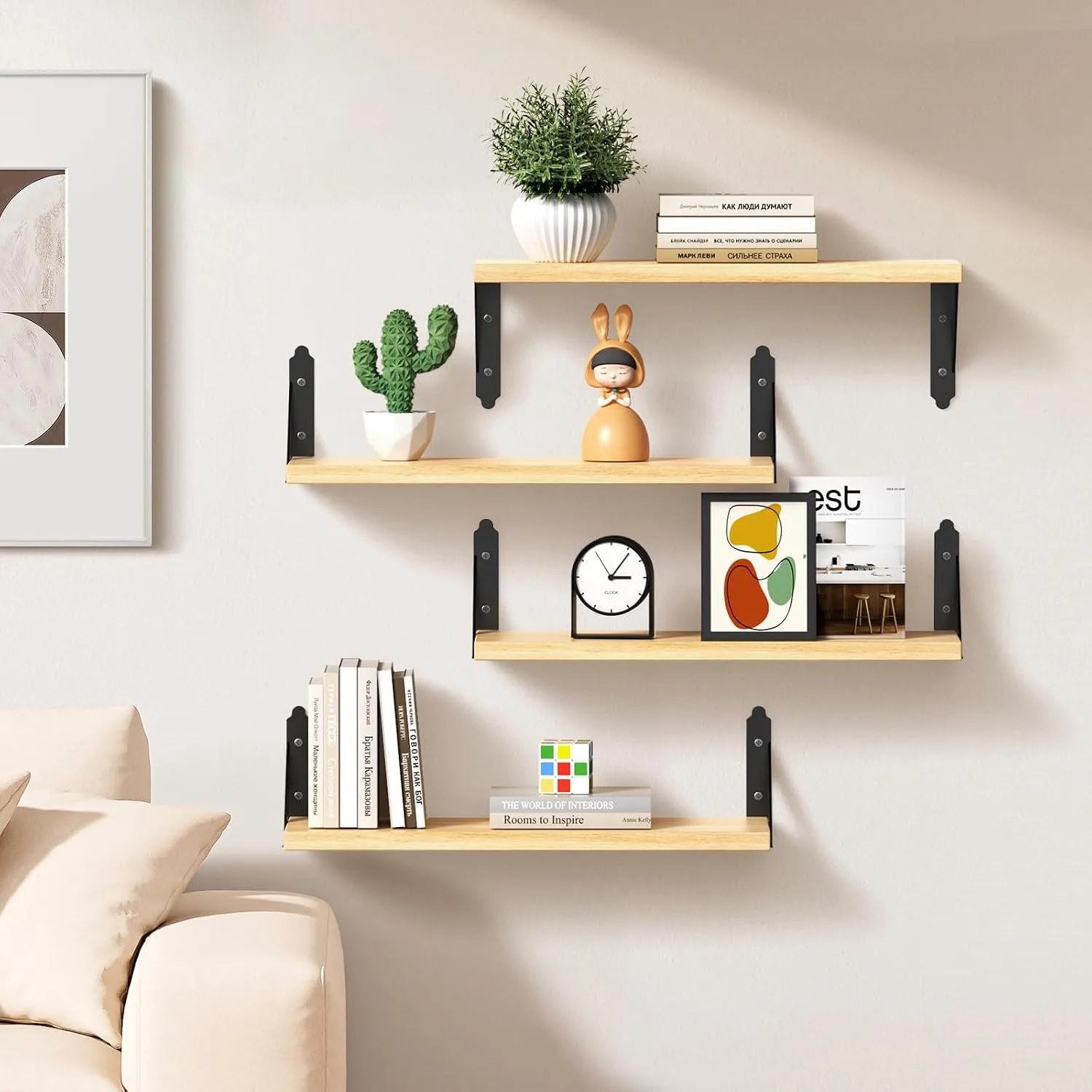 Natural shelves on a living room wall holding a cactus, a clock and books